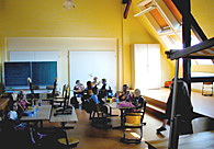 Auf dem Bild sind Menschen zu sehen, die im Dachgeschoss arbeiten.