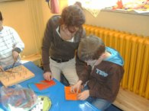 Eine Kleingruppe arbeitet zusammen mit einer Lehrkraft.