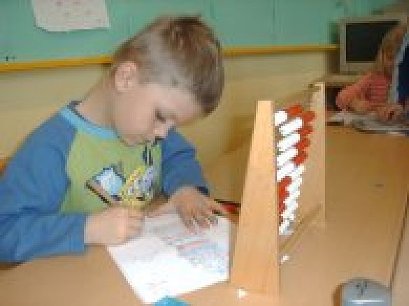 Ein Kind arbeitet mit einem Abakus.